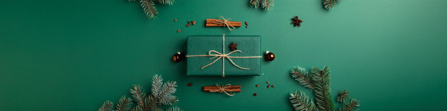 Christmas gift box tied twine pine branches cinnamon sticks ornaments green banner flat lay top view holiday season commerce stock digital design asset marketing template web banner header.