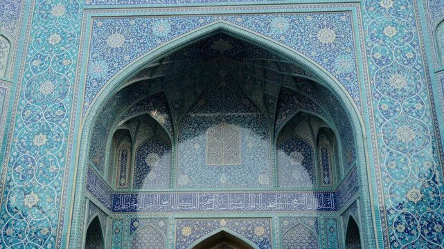 Intricate blue tile mosaic archway with Islamic calligraphy and floral patterns in historic mosque architecture