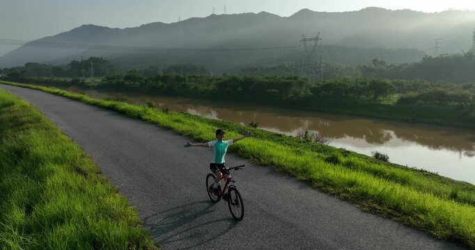 Riding bike without holding the handlebar on beautiful country road