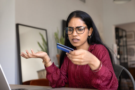Upset Indian woman feels concerned about electronic payment issue, facing declined transaction, unexpected charge, or difficulty verifying her credit card information while shopping or banking online