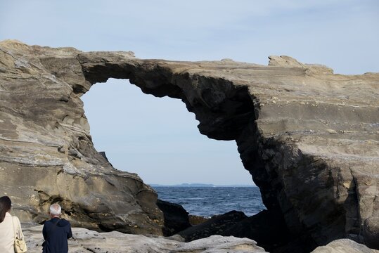 岩のアーチから海が覗く馬の背洞門が雄大な自然の造形を見せる城ヶ島の風景  
Majestic natural rock arch at Jogashima framing the ocean and creating a striking coastal landscape
