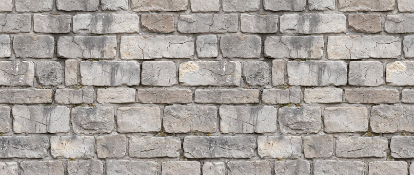 A detailed texture of a weathered grey stone brick wall surface.