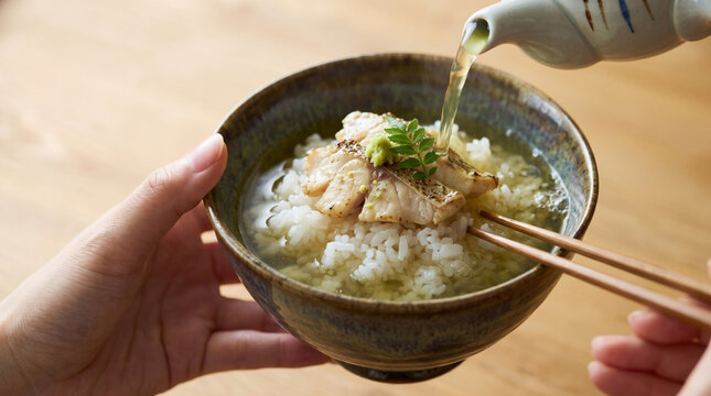 鯛の炙りを乗せた鯛茶漬けに急須から出汁を注ぐ手元 和食と日本料理