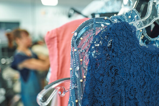 Blue lace dress with beading on a hanger at a thrift store