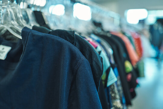 Dark clothing hanging on a rack at a thrift store