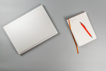 Fototapeta premium Planning work tasks with a laptop and a notebook on a desk