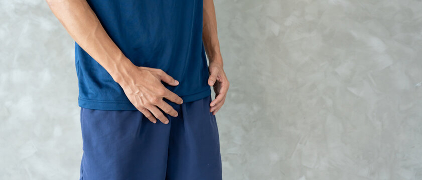 Man hold hand in front of private parts feeling discomfort from disease and inflammation. Venereal, testicular cancer. bladder problems, erectile dysfunction, premature ejaculation, prostate cancer