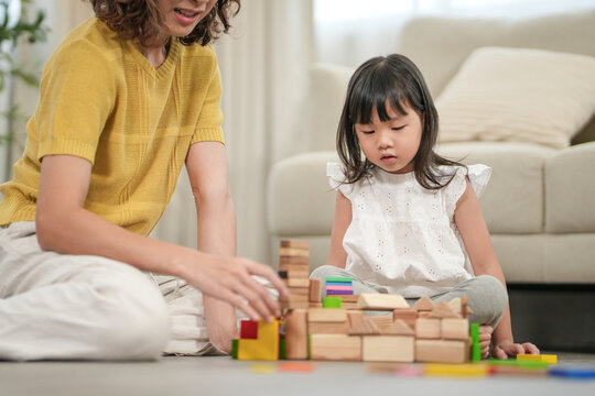 Happy Asia mother play and learn toy blocks with the little girl. Funny family is happy and excited in the house. Mother and daughter having fun spending time together. Holiday, Activity, development