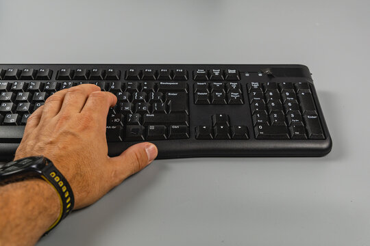 User types on a keyboard while working at a computer in an office
