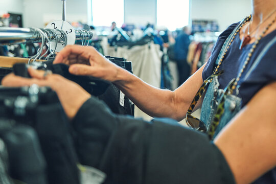 Two women browsing a clothing rack at a thrift store