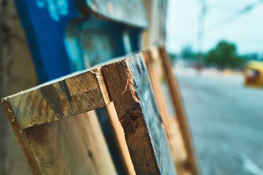 Close-up of a weathered wooden pallet leaning against a building