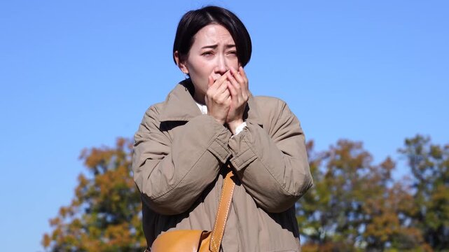 外で凍えるミドルエイジの女性