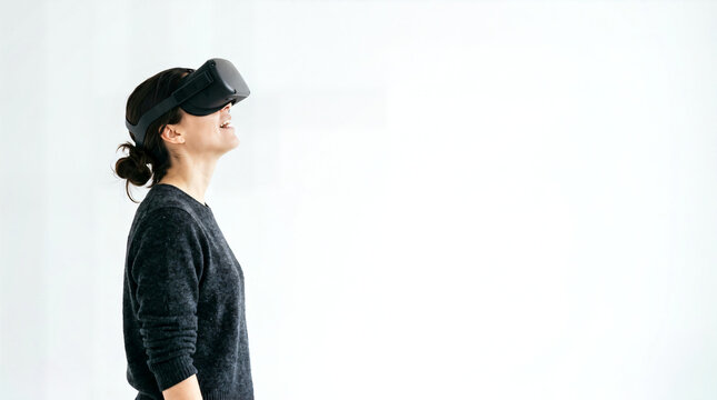 Woman wearing virtual reality headset looking up against a white background