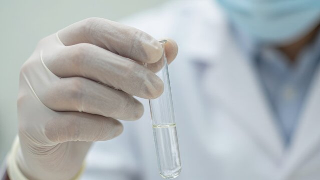 Laboratory Technician Holding Test Tube with Clear Liquid Solution