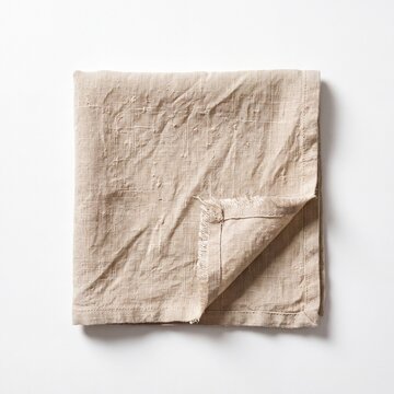 Folded natural linen napkin with slubbed weave and soft creases