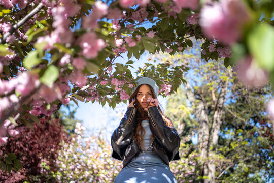 Spring Cherryblossom Girl: Woman poses with flowers under trees on a sunny Spring day.