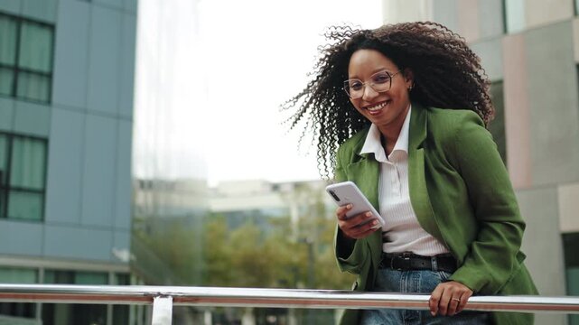 African American Business Woman using cell phone outdoors in the city - Female Professional