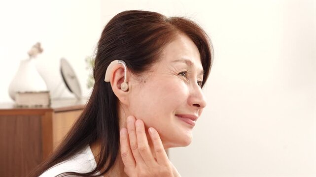 補聴器を付けたシニア女性　リビング