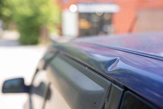 Close-up of a dent on a car body. 