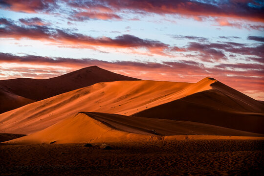 Red Sand Dunes at Sunset with Colorful Clouds