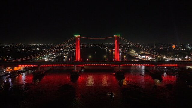 Aerial view of Ampera Bridge glowing in red lights at night in Palembang Indonesia