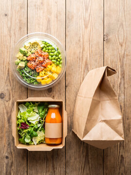 Healthy Food Delivery Set with Salmon Poke Bowl Salad and Juice in Paper Packaging on Wood