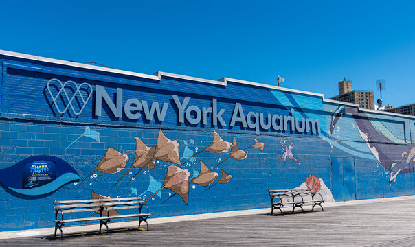 Brooklyn, New York - June 15th, 2026: An outdoor sign on the Coney Island Boardwalk points visitors toward the entrance of the New York Aquarium, the oldest continually operating aquarium in the USA