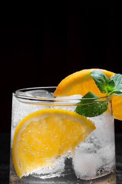 Close Up of Refreshing Citrus Cocktail With Orange Slice Mint and Ice