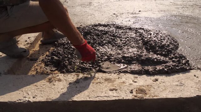 Construction Worker Smoothing Fresh Concrete With Hand 