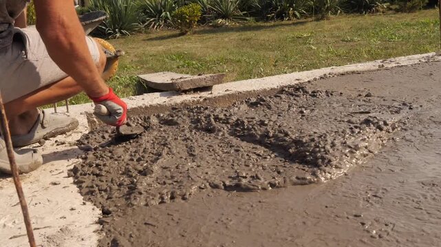Construction Worker Smoothing Fresh Concrete With Hand 