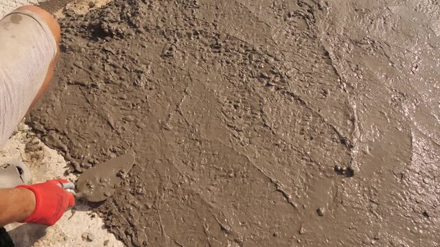Construction Worker Smoothing Fresh Concrete With Hand 