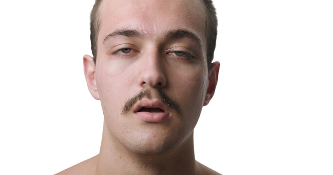 Frontal Close-Up Studio Portrait of Exhausted Young Man Sweating from Extreme Heat