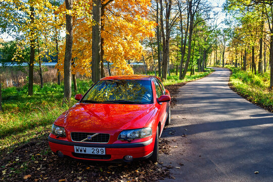 Red car parked on the roadside a beautiful autumn day