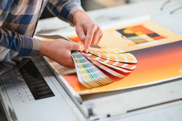 Obraz premium Hand holding color swatch book at printing house