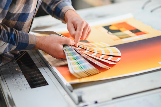 Hand holding color swatch book at printing house