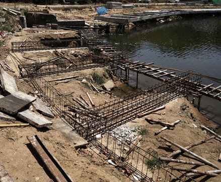 Building process city levee. Exposed foundation rebar grid at site, standing formwork and concrete footings