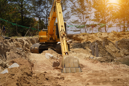 Building process city levee. Excavator dredging pond bank