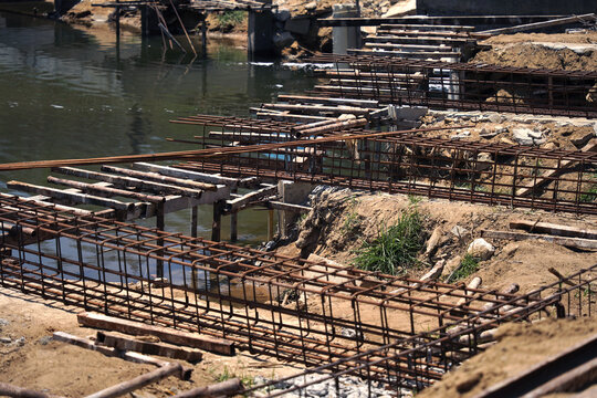 Building process city levee. Exposed foundation rebar grid at site, standing formwork and concrete footings