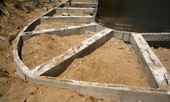 Building process city levee. Exposed foundation rebar grid at site, standing formwork and concrete footings