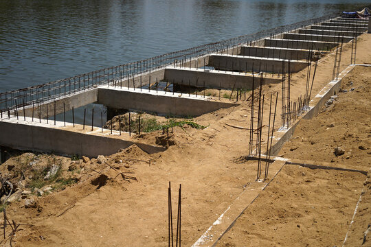 Building process city levee. Exposed foundation rebar grid at site, standing formwork and concrete footings