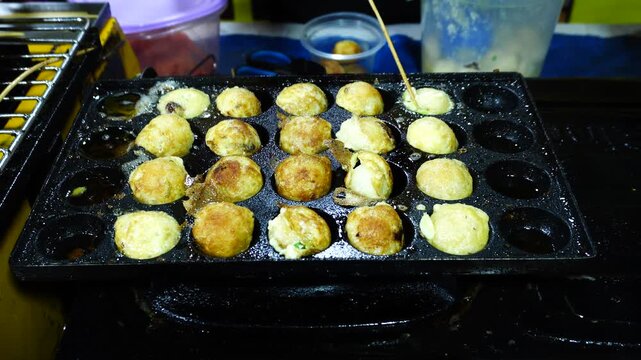 Round Savory Snacks Cooking on a Street Food Griddle