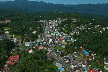 Fototapeta premium Aerial drone photo of residential area and mountain landscape in Kusatsu, Gunma, Japan