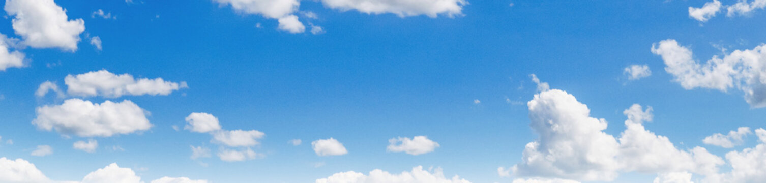 Calm blue sky with soft white clouds drifting