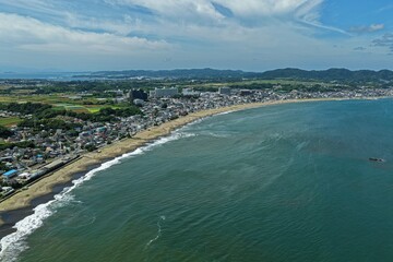 Obraz premium Aerial drone photo of coastline with sandy beach and residential area in Miura, Kanagawa, Japan