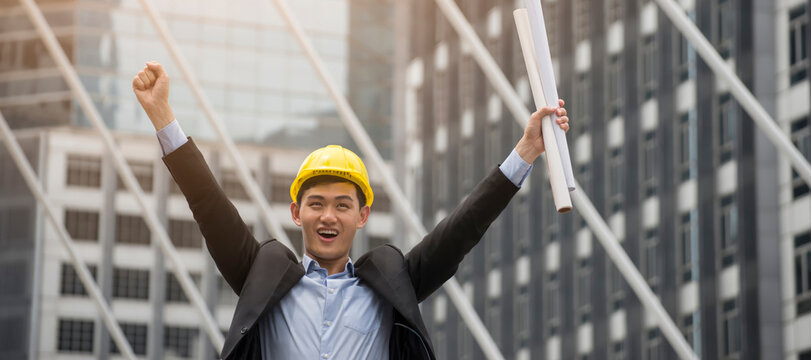 Professional Construction engineer Manager wear safety yellow helmet holding Blueprint feeling success after complete building project with better structures. Construction Engineering concept-banner 