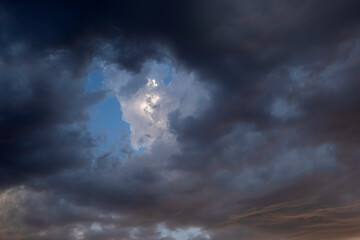 Obraz premium Dramatic storm clouds with blue sky and sunlight breaking through