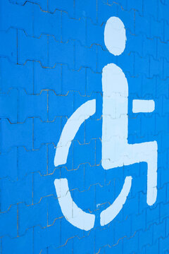 Non-standard perspective on a disability parking road sign. Changing attitudes toward disability, accessibility, and social inclusion, concept. Minimal. Copy space.
