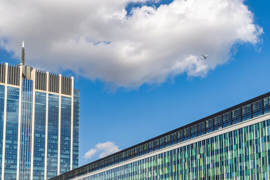 Modern Cityscape with Skyscraper, Contemporary Building, and Distant Airplane Soaring Under a Bright Blue Sky. City of Brussels in Belgium, Europe.