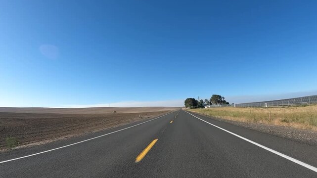 4K action camera footage driving on a rural road near Arlington, Oregon, USA, passing a huge solar panel field surrounded by open farmland in north eastern Oregon