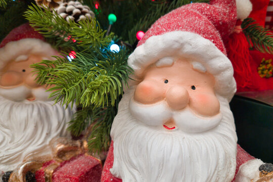 Close up of cute decorative Santa Claus figurine next to Christmas tree